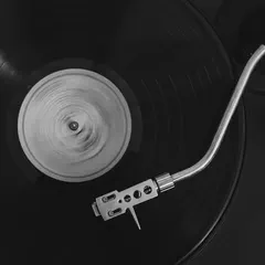 Black and white close-up of a vinyl record spinning on a turntable