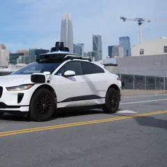 A Waymo autonomous Jaguar I-Pace driving on a San Francisco street with no one in the driver seat
